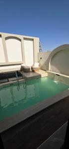 una piscina con sillas en un edificio con agua en Nasma chalets, en Barka 4 fotos más