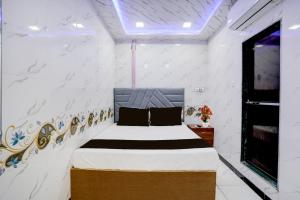 a bedroom with a bed in a white room at Hotel O SR Residency in Mumbai