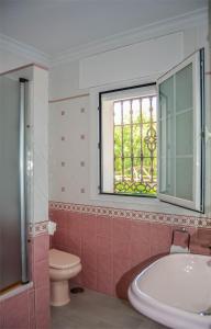 een badkamer met een bad, een toilet en een raam bij CASABA - Boutique - Torre del Mar in Torre del Mar