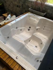 a large white bath tub sitting on a wooden deck at Apartamento Alto Padrão in Porto Belo