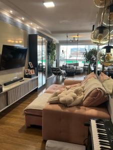 a living room with a couch and a piano at Apartamento Alto Padrão in Porto Belo