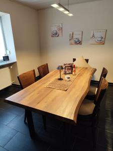 ein Holztisch in einem Raum mit Stühlen in der Unterkunft Ferienwohnung Landblick in Pirmasens + 14 Fotos