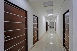 Un pasillo con puertas de madera en un pasillo de hospital. en Hotel O Sector 110 Noida Formerly Luv Kush Tower Bhangel, en Noida