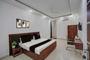 Un dormitorio con una cama y una silla dentro. en Hotel O Sector 110 Noida Formerly Luv Kush Tower Bhangel, en Noida