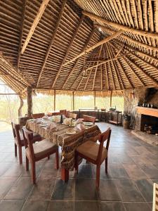 une salle à manger avec une table, des chaises et un toit dans l'établissement Burko Luxury Camp & Lodge, à Arusha
