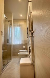 un bagno con due lavandini, un water e una doccia di In Mons Iunonis ad Arezzo Altre 18 foto