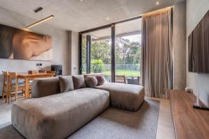 ein Wohnzimmer mit einem großen Sofa und einem Tisch in der Unterkunft MODERN AND COMFORTABLE JUNGLE VISTA HOTEL Ubud Bali By JV with a relaxing atmosphere in Ubud