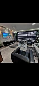 Una sala de estar con un sofá y un televisor de pantalla plana. en Oceanview Frente Mar 130m2, en Santos