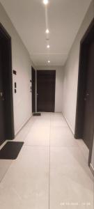 an empty hallway with black doors and white walls at Ptolemeon 20, Apts & Studios Thessaloniki Center in Thessaloniki