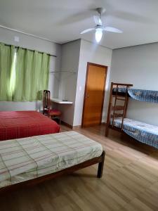 Pousada Pérola Mineira في بيوي: غرفة نوم بها سريرين ومروحة سقف