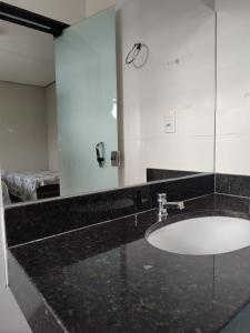 Pousada Pérola Mineira في بيوي: حمام مع حوض ومرآة كبيرة