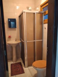 a bathroom with a shower and a toilet and a sink at Casa paulo e nubia in Imbé