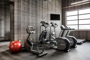 a gym with tread machines and a flat screen tv at enVision Hotel Worcester Downtown in Worcester