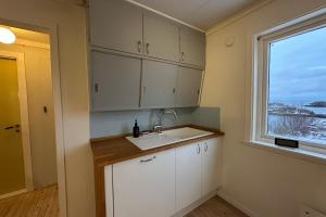 een keuken met een spoelbak en een raam bij Coastal Comfort Ure in Vestvågøya +13 foto's