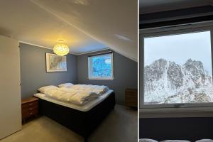 ein Schlafzimmer mit einem Bett und einem Fenster in der Unterkunft Coastal Comfort Ure in Vestvågøya + 13 Fotos