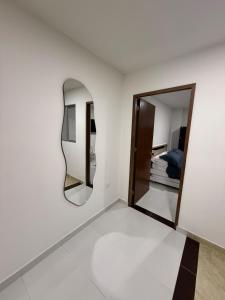 a white room with a mirror and a bed at New Central Apartment 101 in Ocaña
