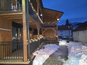 una casa cubierta de nieve con luces encendidas en Luxusný apartmán Karolína, en Telgárt