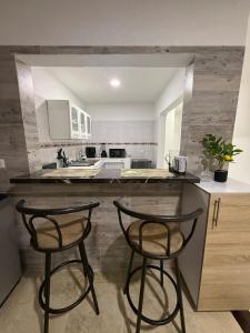 a kitchen with two bar stools at a counter at New Central Apartment 101 in Ocaña