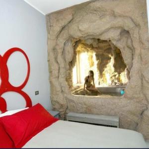 a person sitting in a stone fireplace in a bedroom at Coelho Boutique Hotel in Gatteo a Mare +16 photos