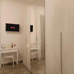 een witte kamer met een bureau en een spiegel bij Sogni di Stelle in Salerno