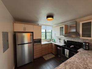a kitchen with a stainless steel refrigerator and wooden cabinets at Aquatika Paraíso Tropical in Loiza