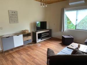 a living room with a couch and a tv at Casa Bella Vista 1 Paraguay in Bella Vista