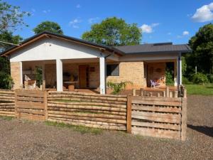 a house with a wooden fence in front of it at Casa Bella Vista 1 Paraguay in Bella Vista