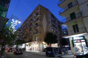 een hoog gebouw op een stadsstraat 's nachts bij One home in Salerno