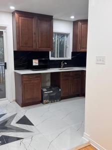 Charming Family Home in Peaceful Laval في لافال: مطبخ فارغ مع دواليب خشبية ومغسلة +7 صور