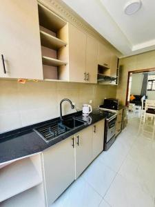 une cuisine avec un évier et un plan de travail dans l'établissement Iwabo Apartments Kigali Airport Kanombe, à Kigali