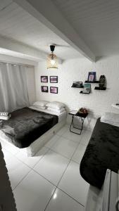 a bedroom with a bed and a table in it at Casa do Point in Saquarema