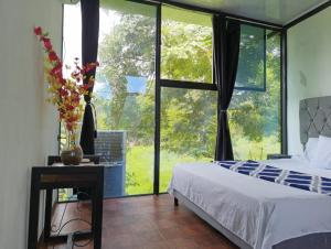 a bedroom with a bed and a large window at Casa siboney in Estación El Salto