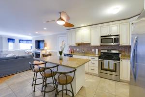 a kitchen with white cabinets and a island with bar stools at Spacious Wildwood Townhome with Covered Balcony in Wildwood