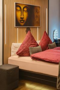 a bed with red pillows and a picture of a woman at Unterkunft in Altstadt in Schongau