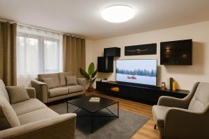 a living room with a tv and a couch and chairs at Unterkunft in Altstadt in Schongau