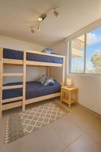 una camera da letto con due letti a castello e una finestra di Depto Ocean View Algarrobo Norte - Piscina, WiFi y Estacionamiento ad Algarrobo
