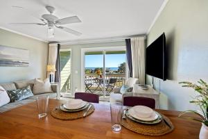 216A Sea Cabin في جزيرة النخيل: غرفة معيشة مع طاولة طعام مطلة على المحيط