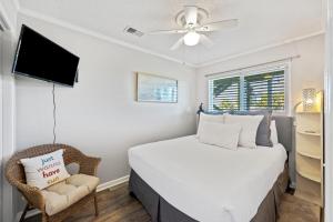 216A Sea Cabin في جزيرة النخيل: غرفة نوم بسرير مع مروحة سقف وكرسي +26 صورة