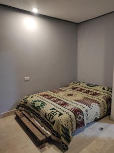 a bedroom with a bed with a blanket on it at Home Sweet Home Riobamba Chimborazo in Riobamba