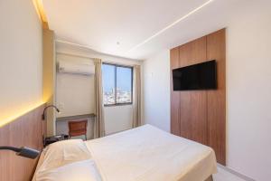 a bedroom with a bed and a flat screen tv at Majestic Rio Palace Hotel in Rio de Janeiro