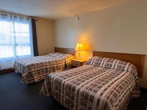 a hotel room with two beds and a window at Discovery Inn in Yellowknife +21 photos