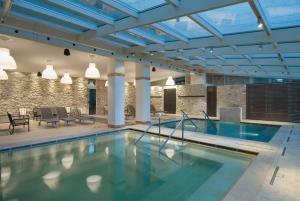 een zwembad in een gebouw met blauwe plafonds bij Albergo Le Terme in Bagno Vignoni
