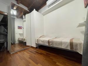 a bedroom with a bed in a room with a mirror at La Casa di Alissia a Brescia in Brescia