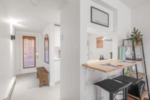 a kitchen with white walls and a counter with a table at Hameau 26-33 studio in Stoneham