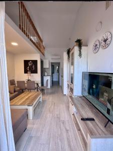 a living room with a large flat screen tv at Maspalomas Lago 36 in Maspalomas