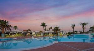 a pool at the resort at sunset at Maspalomas Lago 36 in Maspalomas