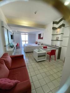 un salon avec un canapé et un lit dans l'établissement Suíte Golden Beach Frente Mar, à Récife
