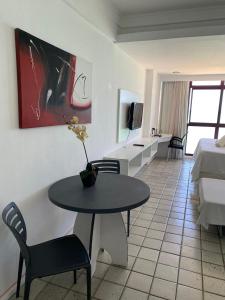 un salon avec une table et une chambre dans l'établissement Suíte Golden Beach Frente Mar, à Récife
