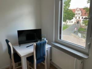 Zimmer mit einem Schreibtisch, einem TV und einem Fenster in der Unterkunft Hotel &Restaurant Meteora in Glauchau + 26 Fotos