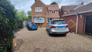 two cars parked in the driveway of a house at Quiet Loft Double Room forty-five minutes by train to London Liv Street in Braintree
